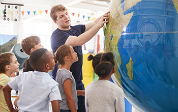 Teacher shows kids giant globe