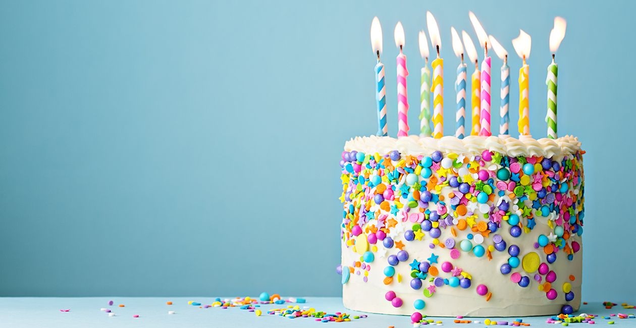 Birthday cake decorated with colorful sprinkles and ten candles